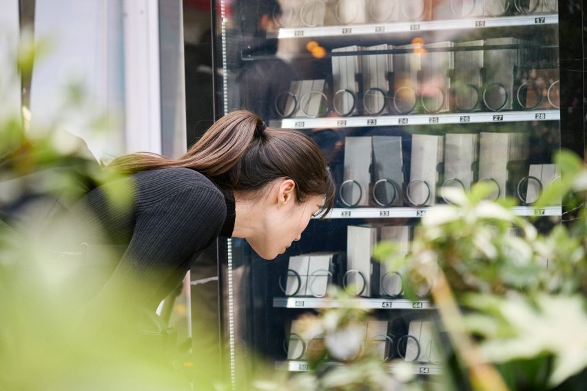 Woman looking at tiles in a vending machine by Solus Ceramics
