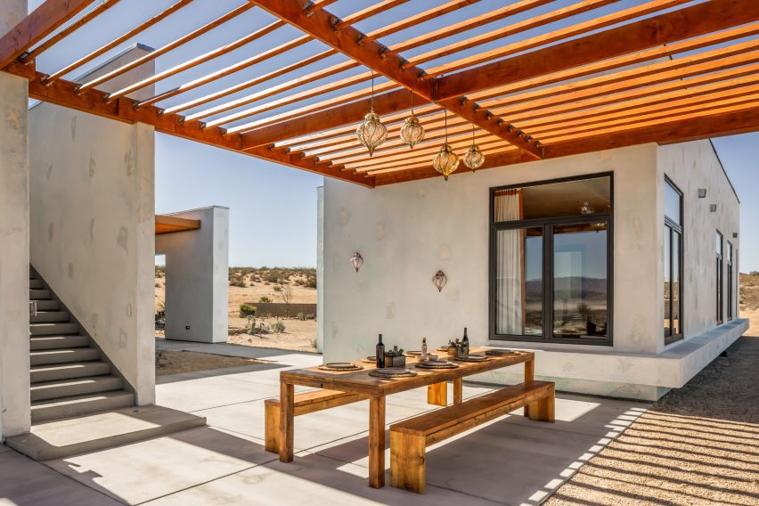 Outdoor dining area shaded by a wooden pergola