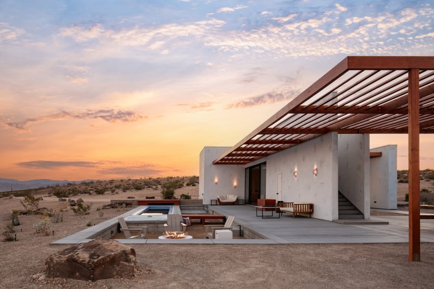 Desert home at sunset, with outdoor living spaces under a wooden pergola