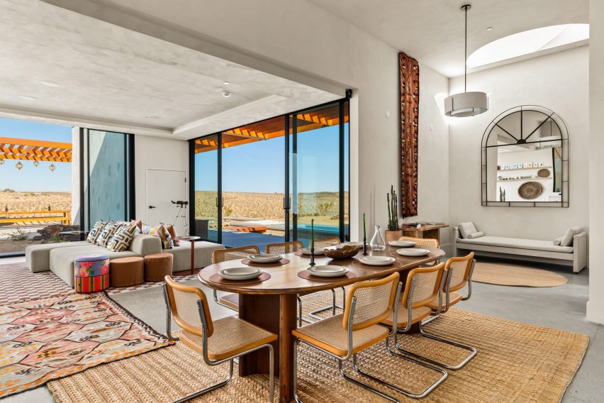 Open-plan living and dining area with sliding glass walls