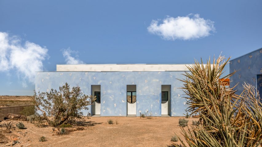 Facade of a single-story building covered in sky-blue, textured cat-face stucco