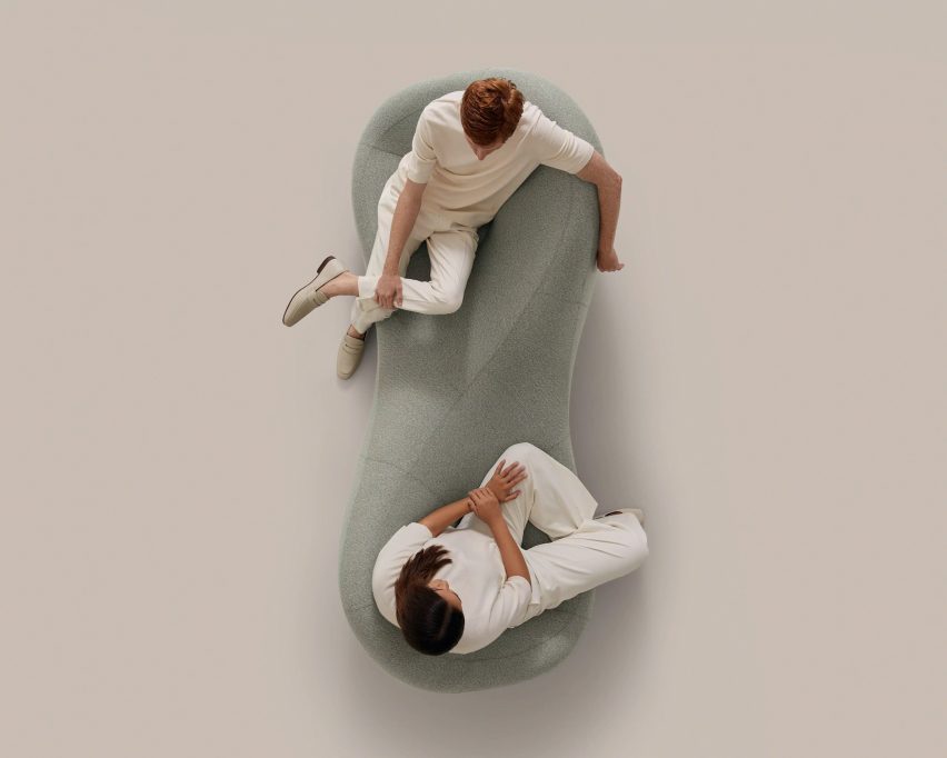 Overhead shot of two people sitting on a grey tete-a-tete bench