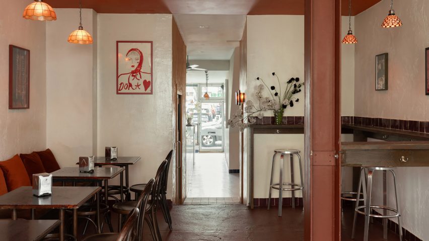 Bar interior with wooden seating, glass pendant light shades and paintings on the wall