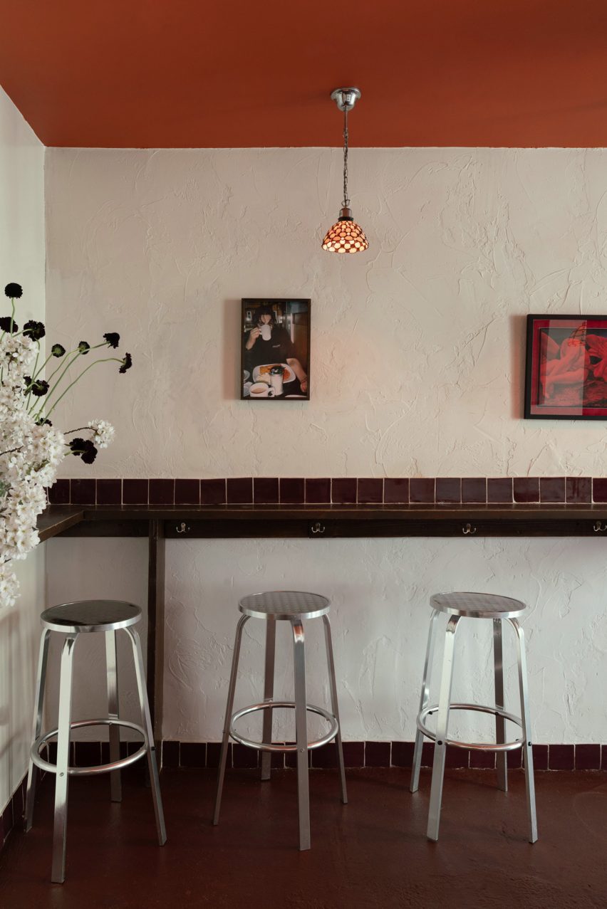 Bar interior with aluminium bar stools and red ceiling