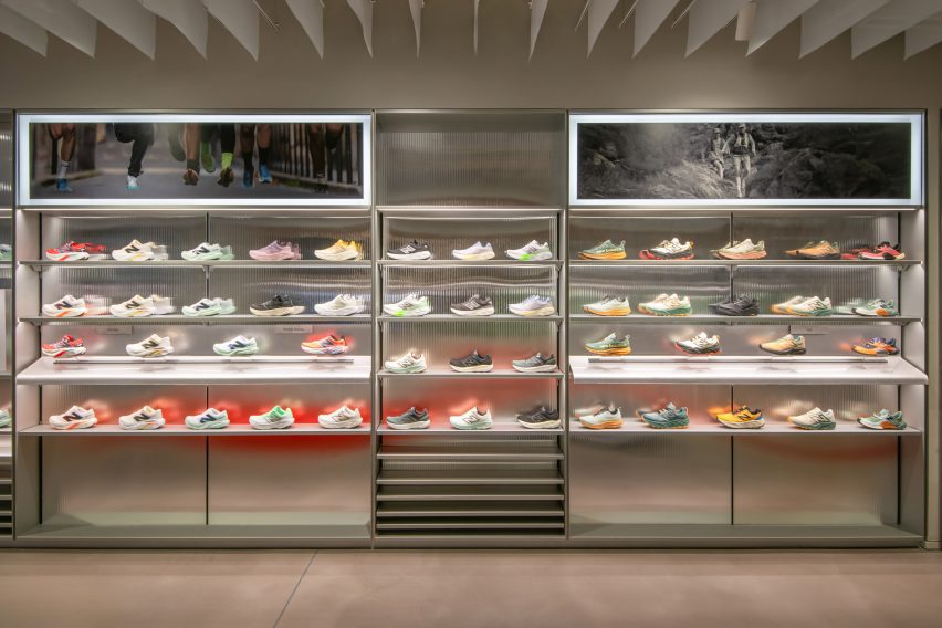 Metal shelves displaying trainers in sportswear store interior by MAP and Universal Design Studio