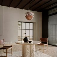 Stone and marble table with amber pendant light hanging above