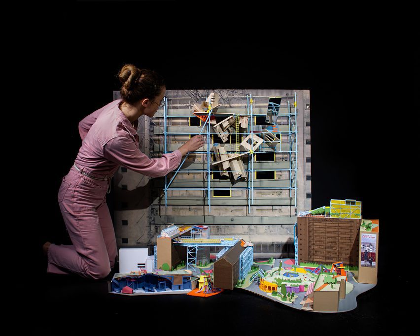 a photograph of a person tending to an architectural model