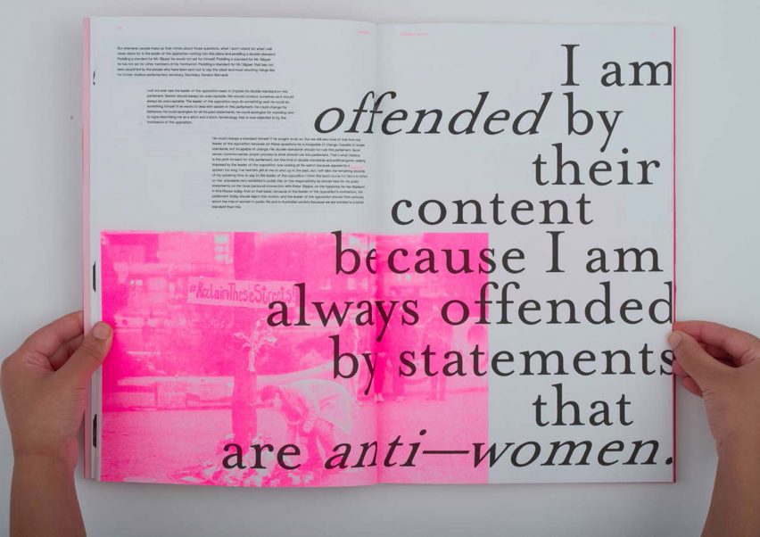 a photograph of a person holding an open book; pages showing black text and tones of white and pink