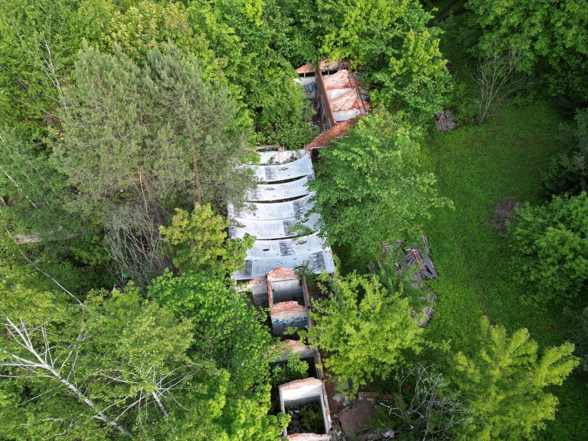 a photograph of ruins of a building from above, in amongst greenery