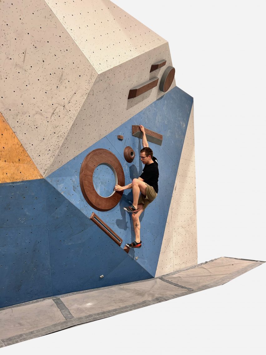 a photograph of a person on a climbing wall in tones of blue and beige 