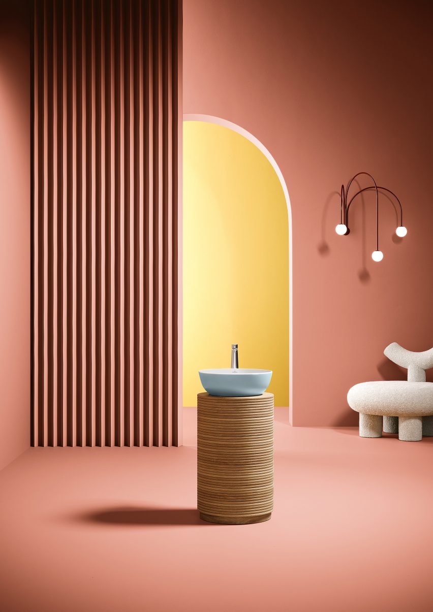 Promotion image of the Villeroy & Bosch Artis surface-mounted washbasin in the pale blue colour Frozen, set on a plinth within a coral-pink set