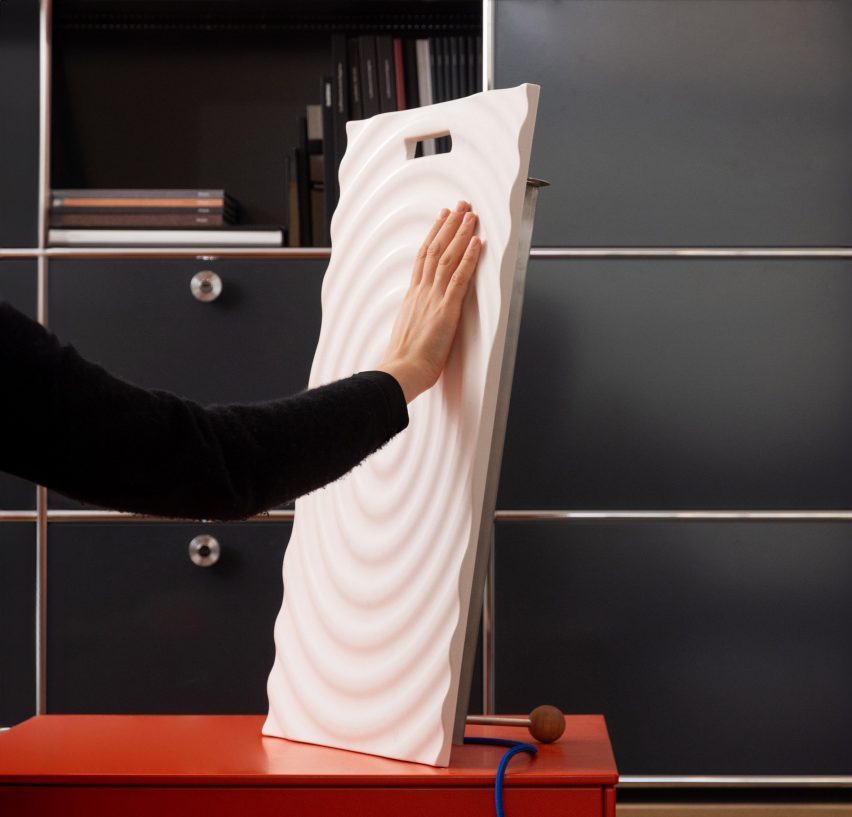 a photograph of a person's hand touching a white textured board
