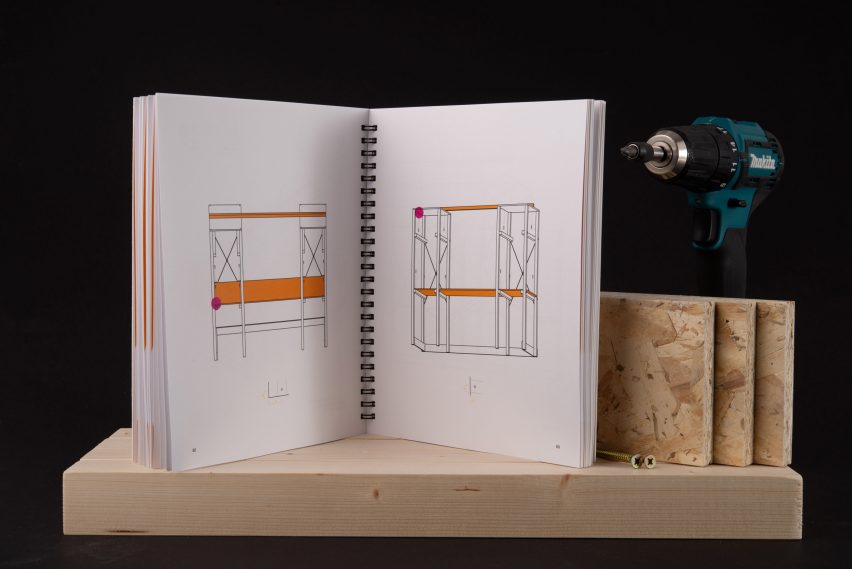 a photograph of an open book atop a brown wooden shelf with diagrams inside in tones of black and orange