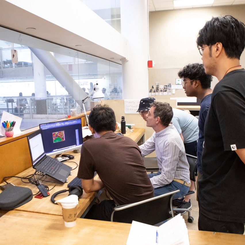 a photograph of students gathered around a desk