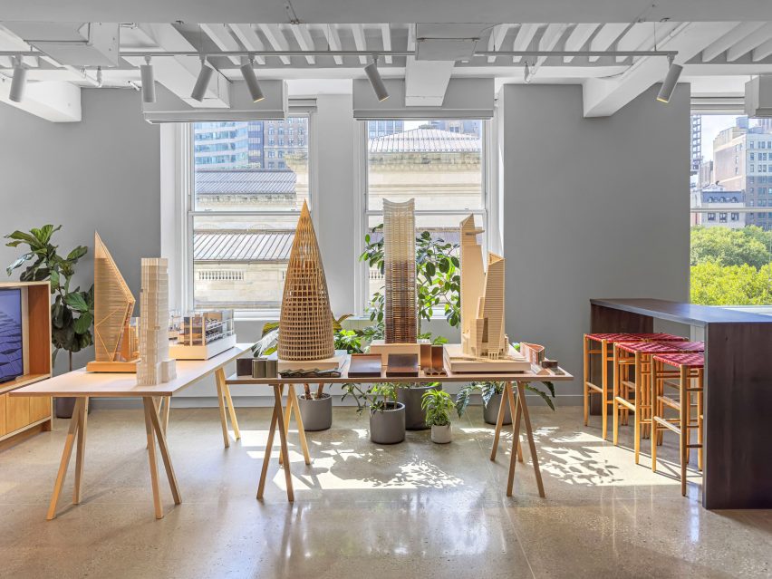 Series of wooden architectural models displayed on trestle tables