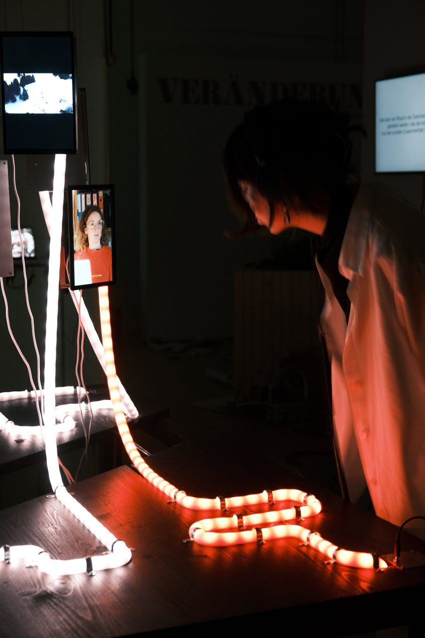 a photograph of a person looking at an illuminated design in an exhibition setting
