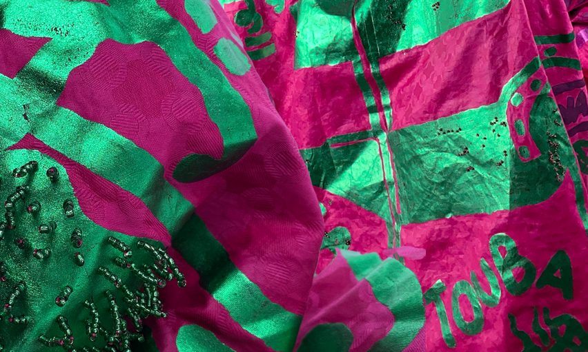 a photograph of a sheet of fabric in tones of green and pink