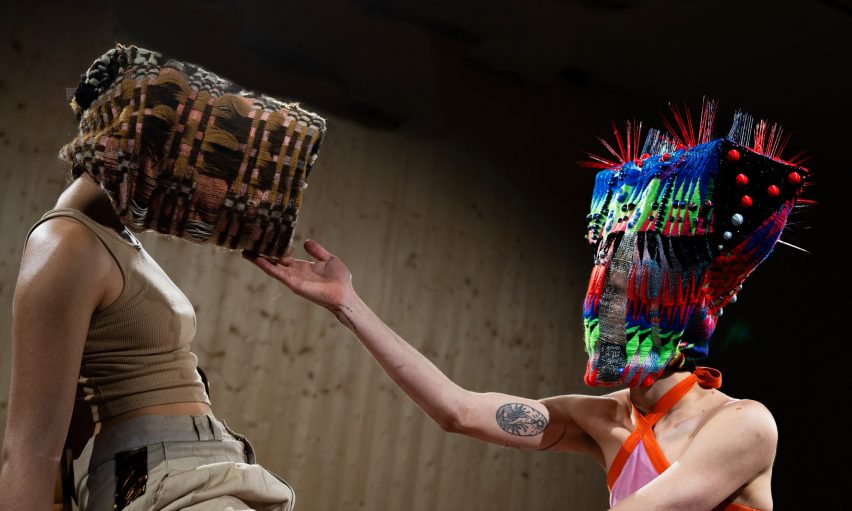a photograph of two people wearing large headmasks and facing one another