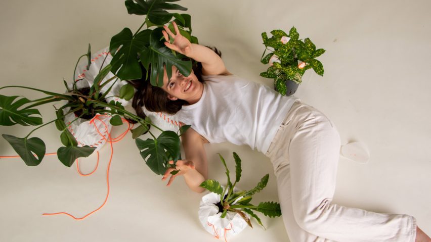 a photograph of a person lying on the floor with green plans around them