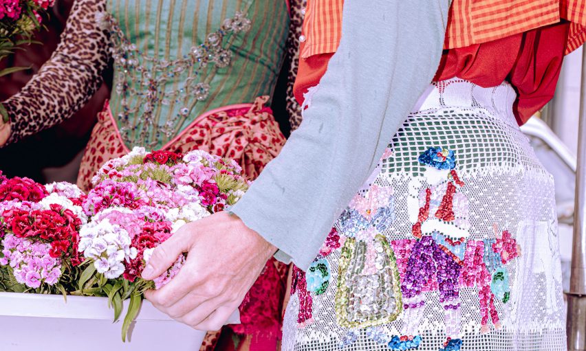 a cropped photograph of people wearing garments in tones of green, pink, red and white