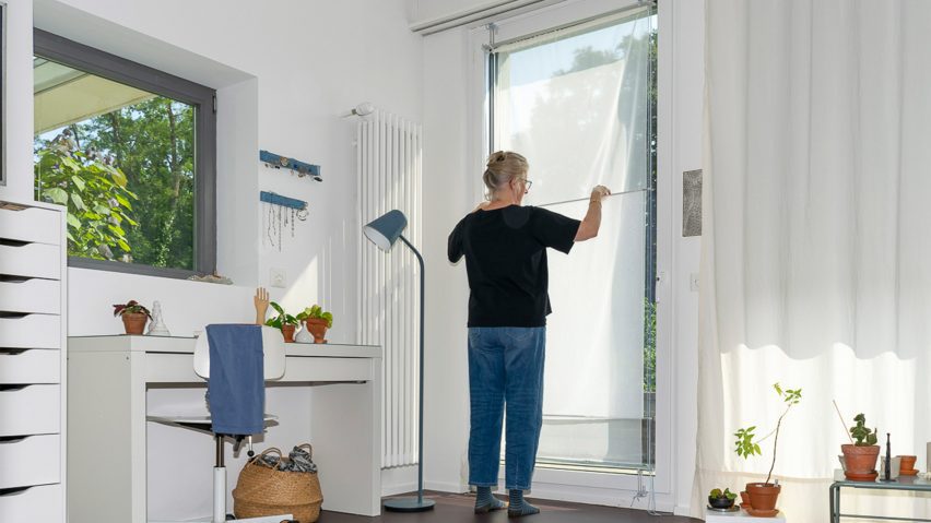 a photograph of a person at a window in a white room