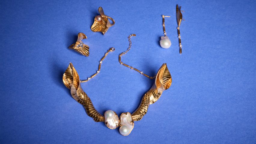 a photograph of gold and pearl jewellery against a blue surface