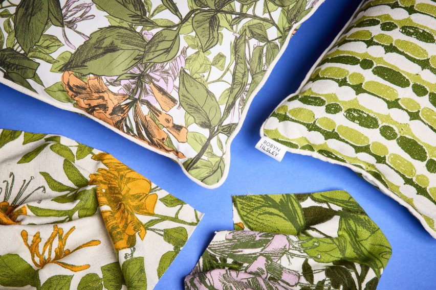 a photograph of cushions against a blue backdrop with floral prints on them
