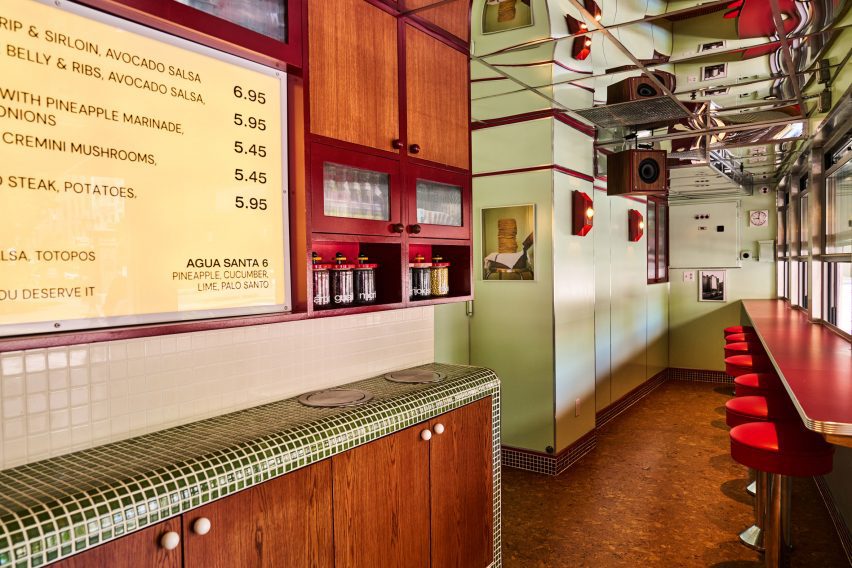 Restaurant interior featuring cork flooring and a mirrored stainless-steel ceiling