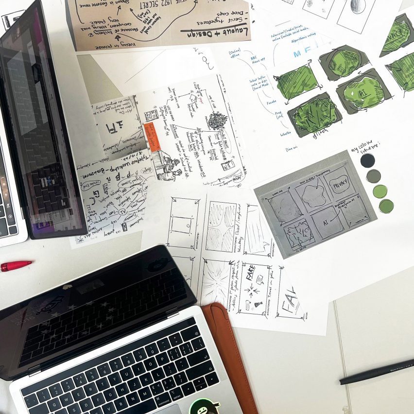a photograph of a desk with paper and laptops on it