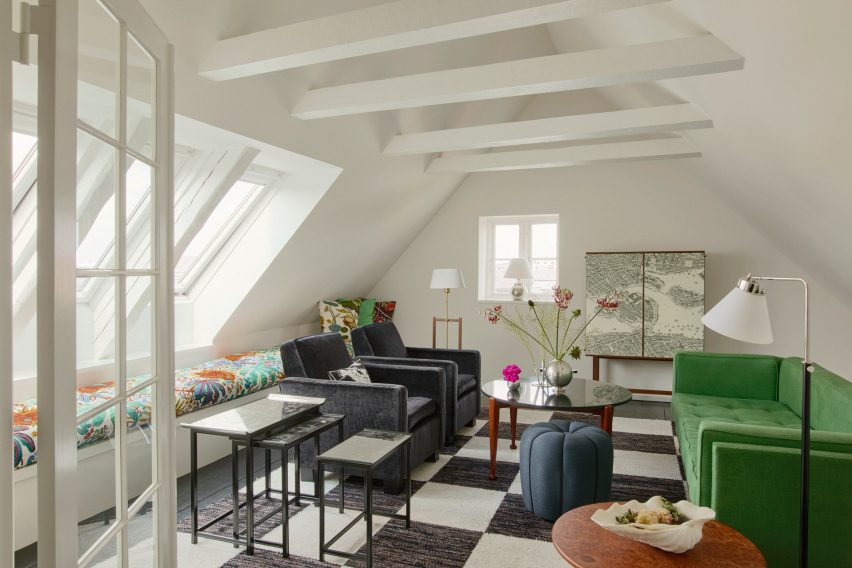 Green sofa on black and white floor