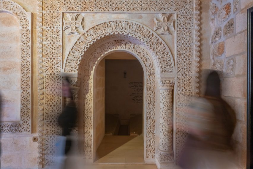 Photo of an archway with people walking in front of it