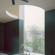 Kitchen sink with semi-circular cut-out in plywood mezzanine above