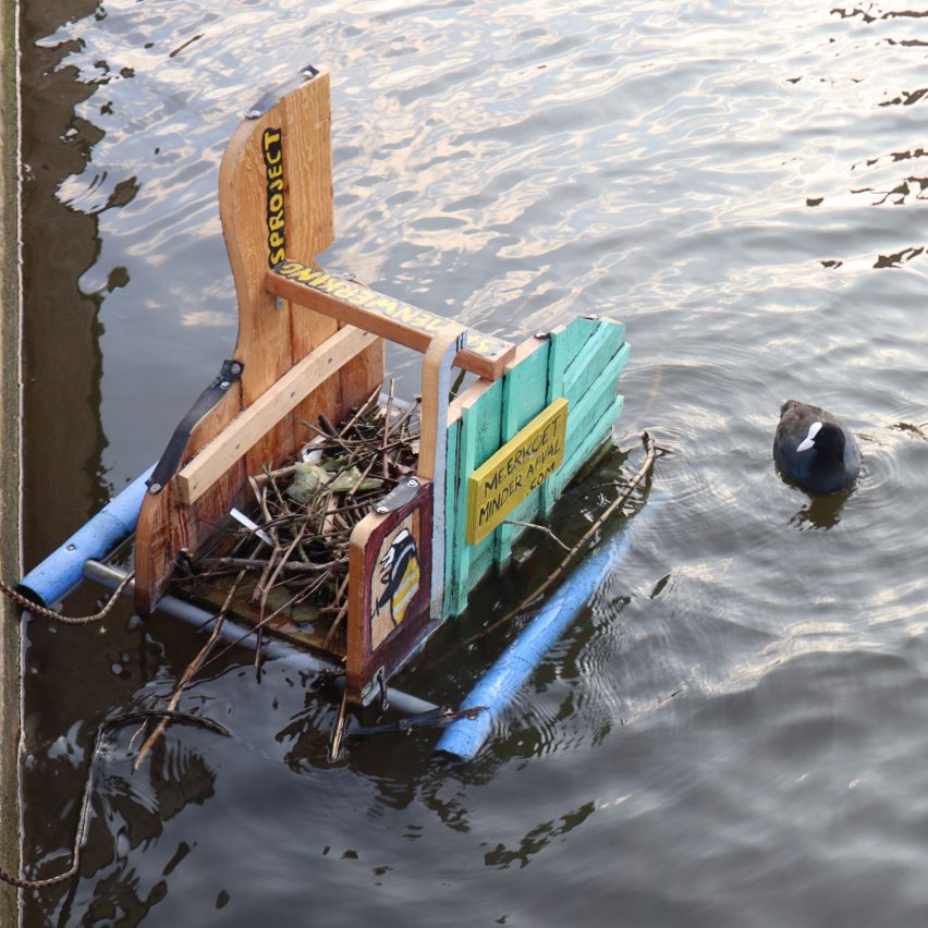a photograph of a wooden structure holding a duck's nest on water