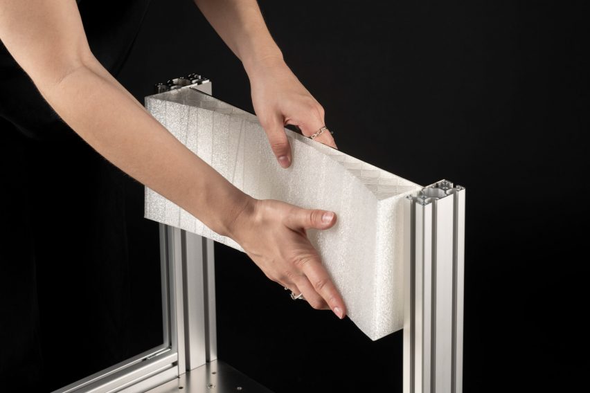 a cropped photograph of a person's hands on the top of a chair in tones of silver and white