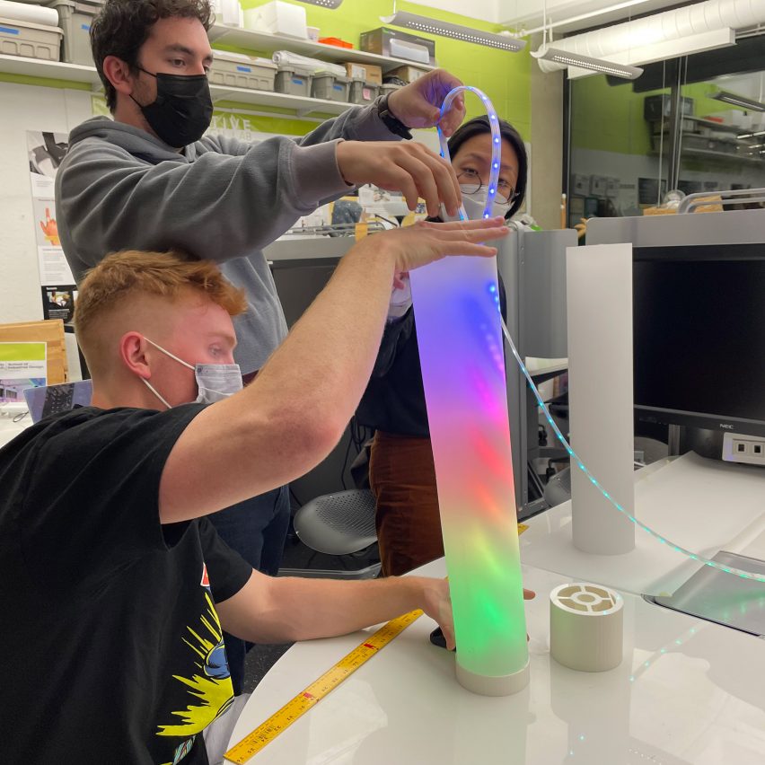 a photograph of interactive design students with a multicoloured object