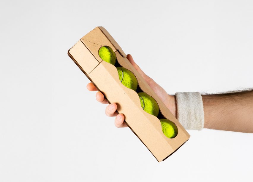 Hand holding cardboard tube containing tennis balls