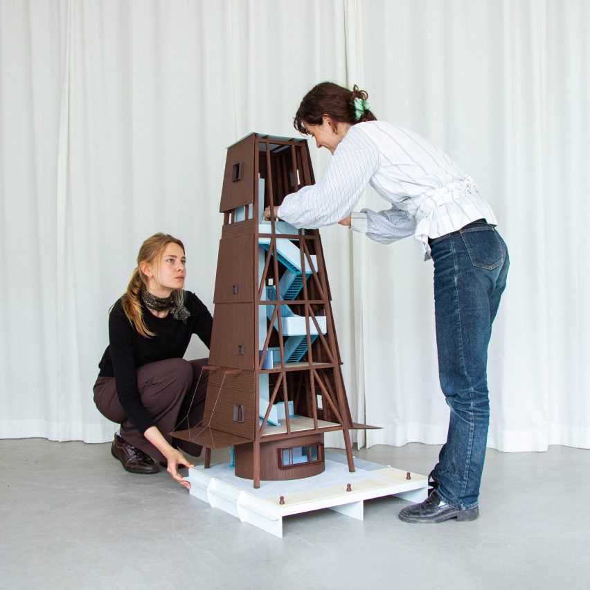 a photograph of two people and an architectural model