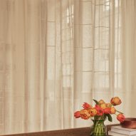 Neutral workspace with large factory windows and sheer curtain