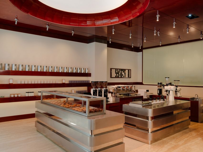A circular lightbox within a glossy wood ceiling positioned over a cafe service area