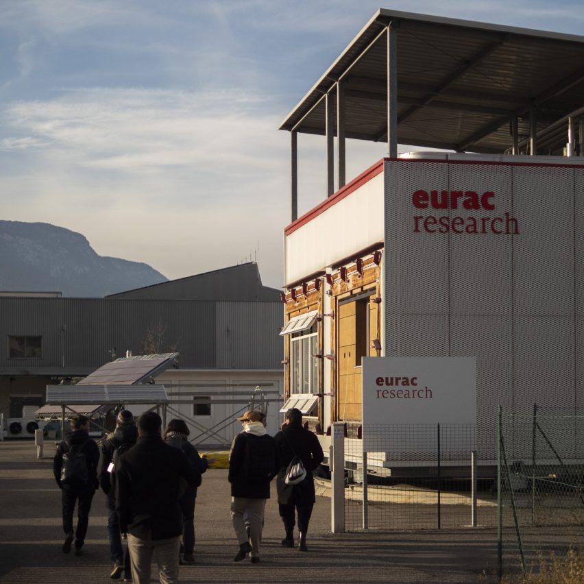 a group of people standing next to a building in tones of white and red