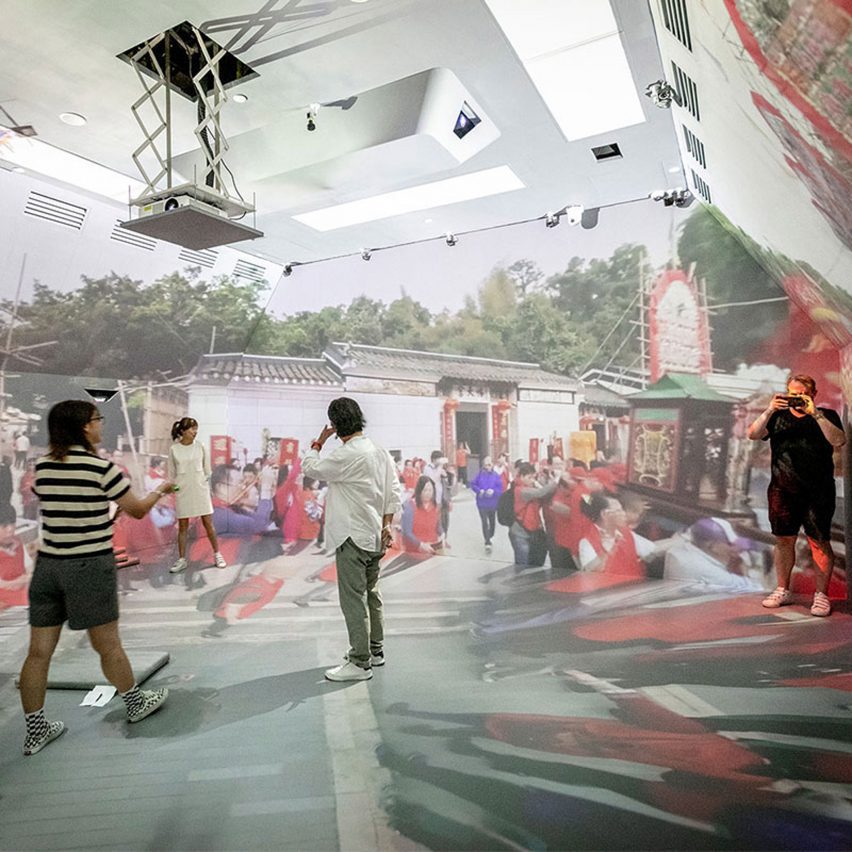 people standing in a room with projections on the walls