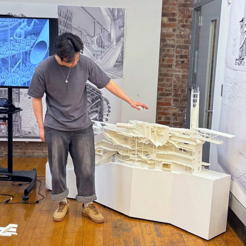 a photograph of a student presenting an architectural model