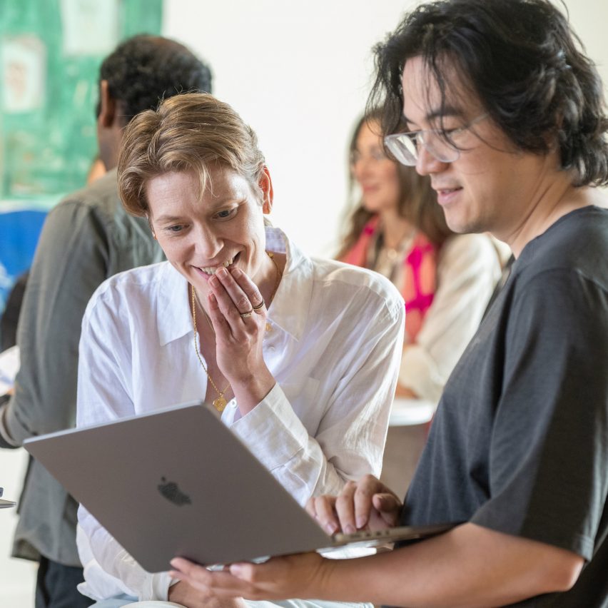 a photograph of a student showing their tutor their work
