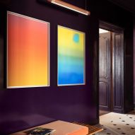 Photograph of a deep purple hallway with two colourful artworks on the wall.