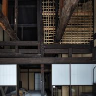 A photograph showing one of the guest bedrooms with an extensive wooden beam structure and washi-paper screens.
