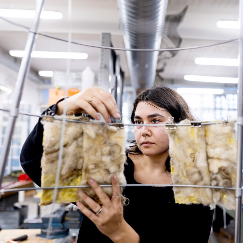 a photograph of a person placing textiles on a hanger