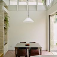 Dining table below clerestory windows in Stone and Steel House extension by DGN Studio and Sarah Izod