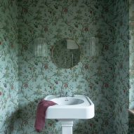 Bathroom with wallpaper in revamp of 1960s villa by StudioTamat