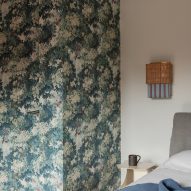 Bedroom with wallpaper in revamp of 1960s villa by StudioTamat