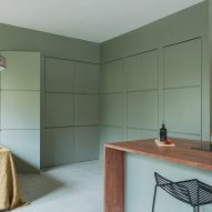 Mint-green kitchen with red travertine island in revamp of 1960s villa by StudioTamat